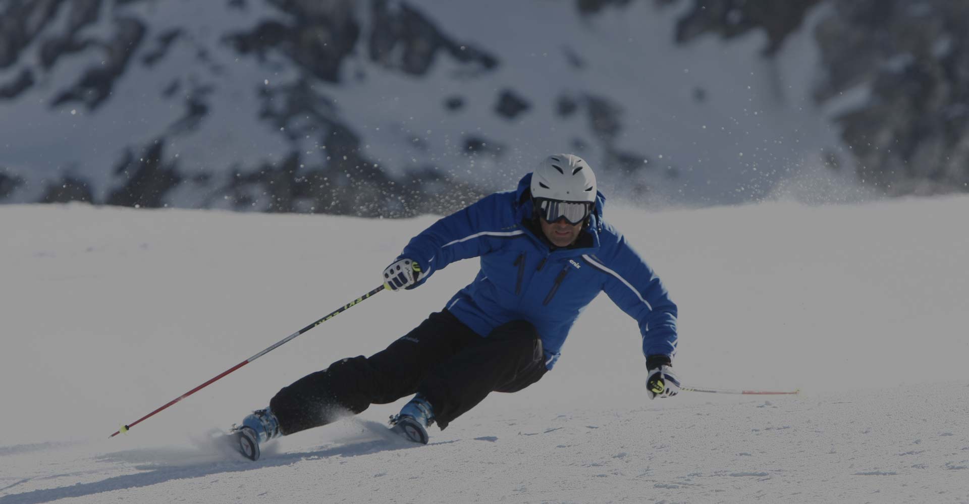 Sciatore felice con sci in spalla noleggiati da Delbono mountain rent